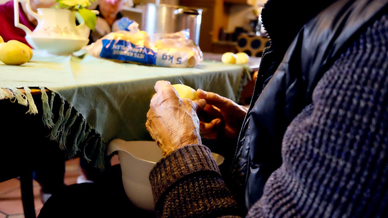 Persoon In Zwart En Paars Jasje Voor Grijze Tafelmat