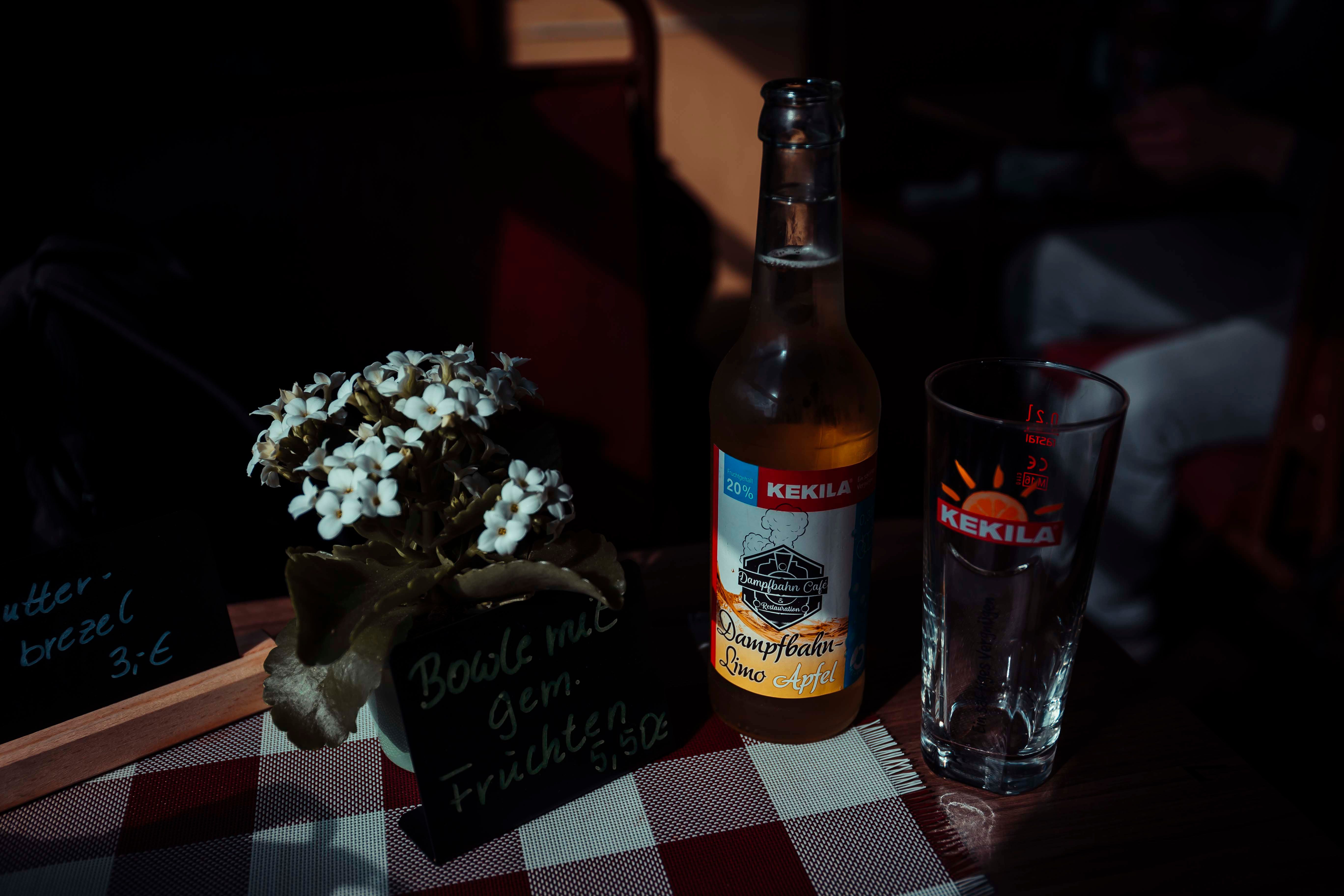 Refreshing Apfelschorle drink next to a freshly baked German Bretzel