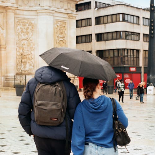 A couple walking under an umbrella