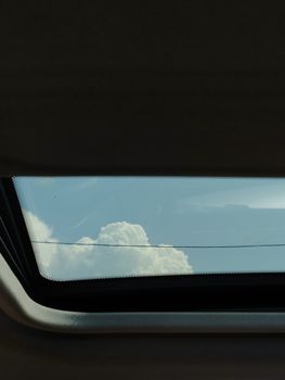 透过汽车天窗，可以欣赏云层美景，展现开阔的天空与车辆设计