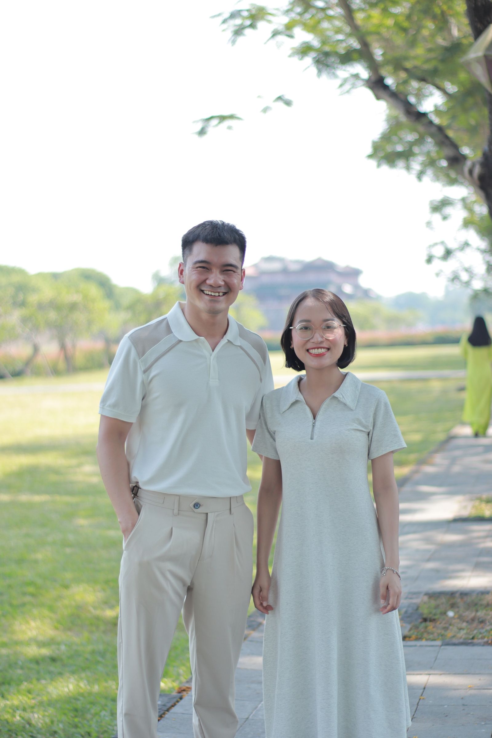 Two people standing together in a leafy park