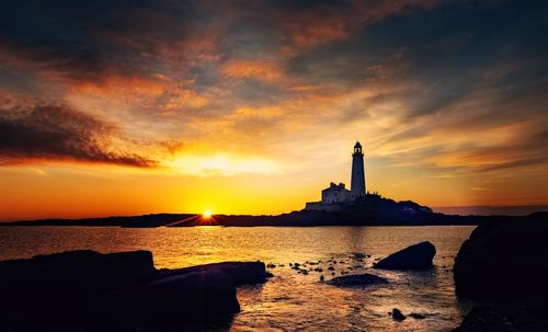 Free Beautiful sunset view of St Mary's Lighthouse by the coast. Stock Photo
