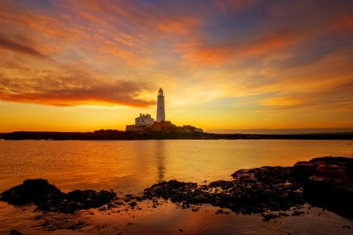 Free Stunning view of St. Mary's Lighthouse against a vibrant sunset on the North Sea coast. Stock Photo