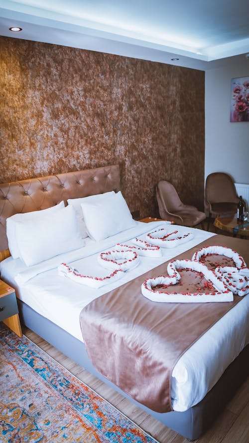 A bed with a heart shaped pillow and a bedspread