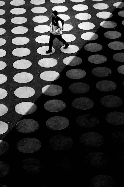 Free A person walking on a black and white polka dot floor Stock Photo