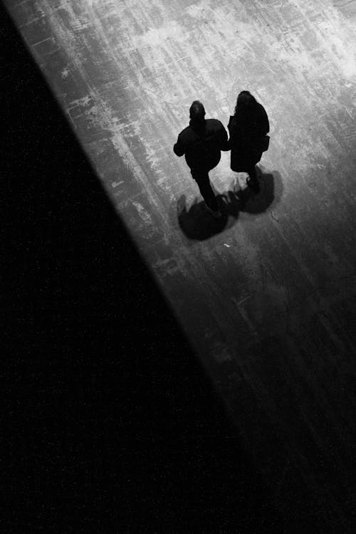 Free A black and white photo of two people walking on a stage Stock Photo