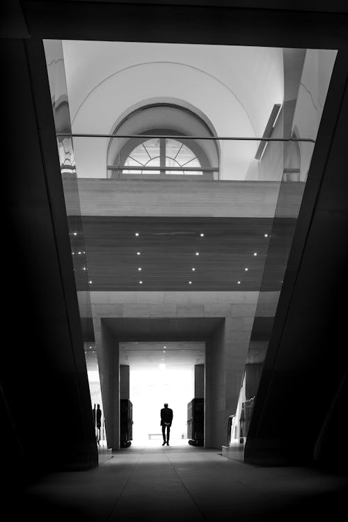 Silhouette of a Person Walking in the Hallway of a Modern Building 
