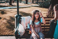 一位年轻女子在公园里微笑着，沐浴在明媚的阳光中，四周环绕着大自然