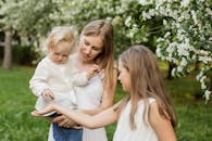 一位母亲和她的孩子们在郁郁葱葱的花园中享受春日，感受家庭之爱