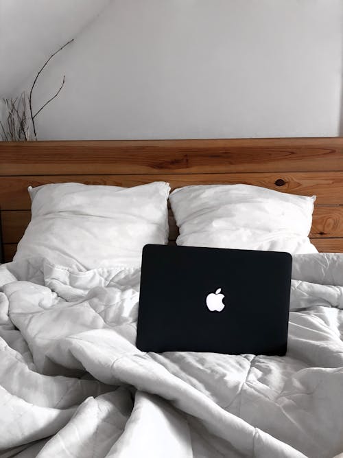 Black Mac Laptop on Creased Bedding