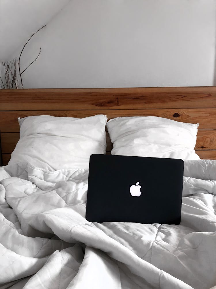 Black Mac Laptop On Creased Bedding