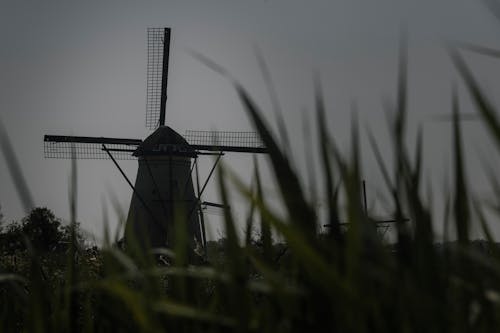 A windmill is silhouetted against the sky