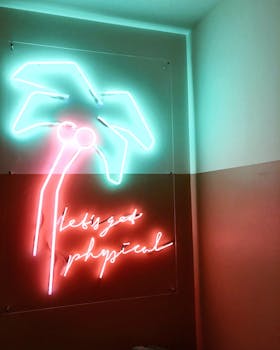 在巴黎会场，充满活力的霓虹灯棕榈树标志上写着“让我们变得身体”的文字