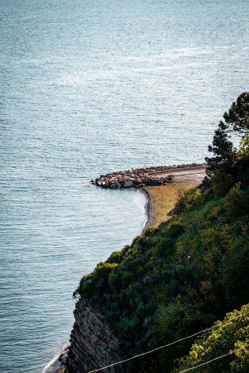 Free A breathtaking aerial view of a rocky coastline with lush greenery. Stock Photo