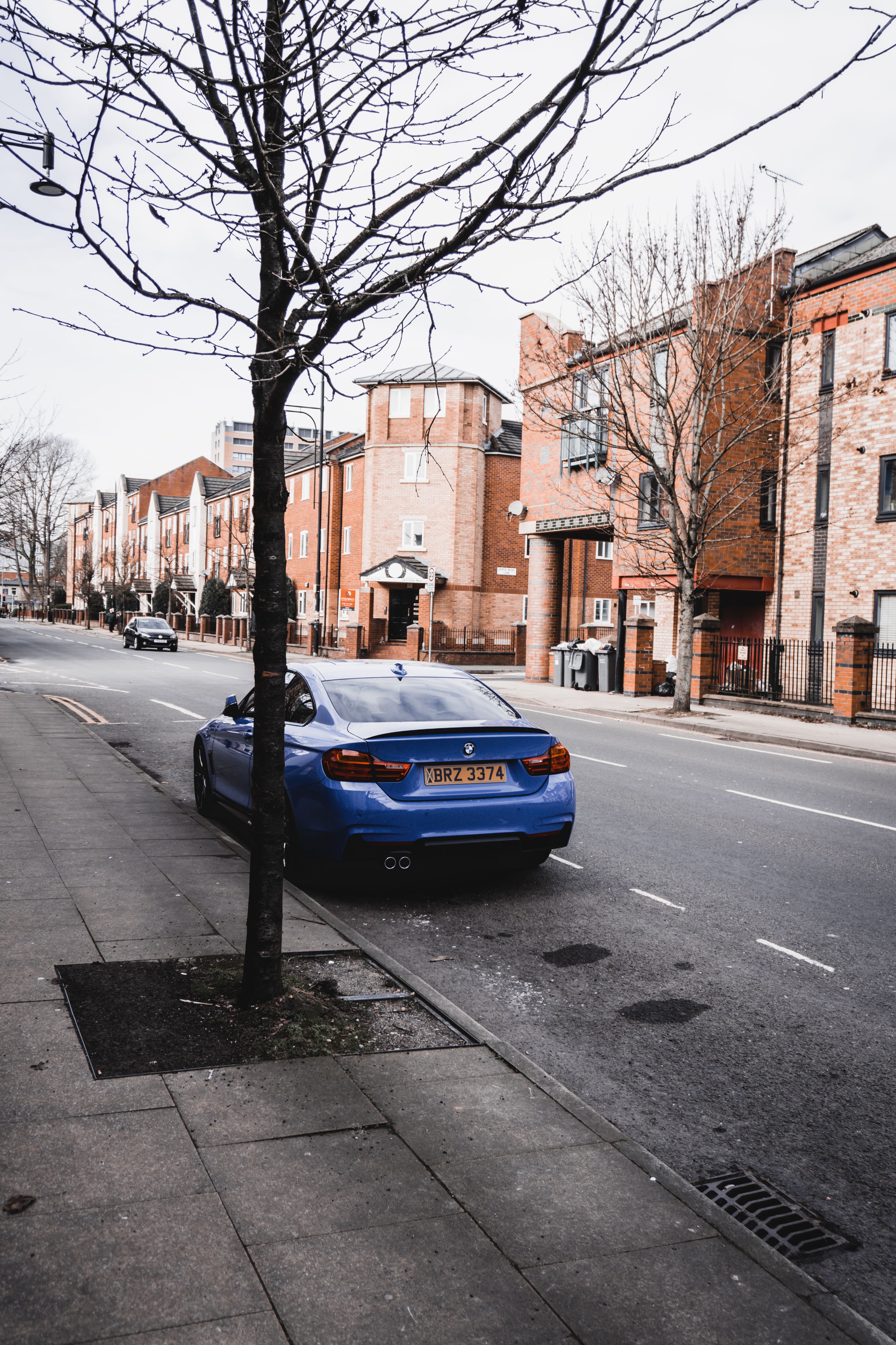 A blue car parked on the side of the road · Free Stock Photo