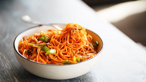 A bowl of noodles with vegetables and meat