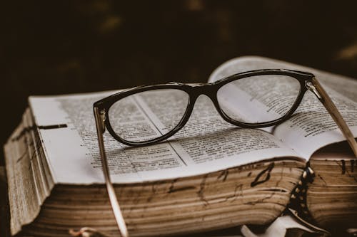 Lunettes Encadrées Noires Sur Le Dessus Du Livre Ouvert