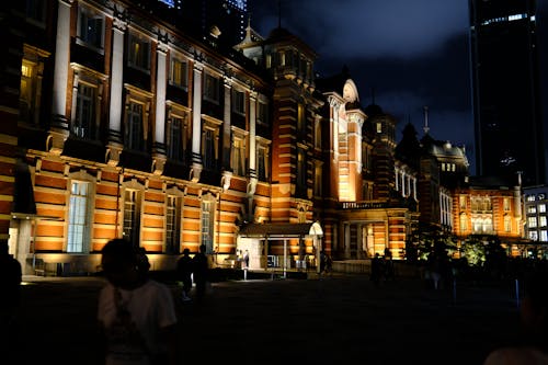 A large building at night with people walking around
