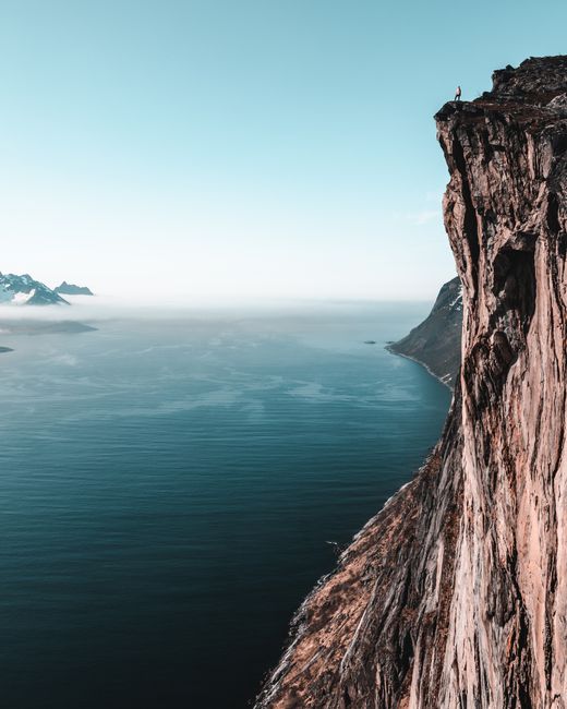 A breathtaking view of a towering cliff overlooking a vast ocean, perfect for adventure seekers.