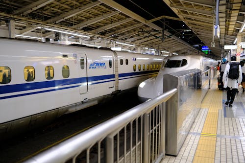 A train is parked at a station with people on the platform