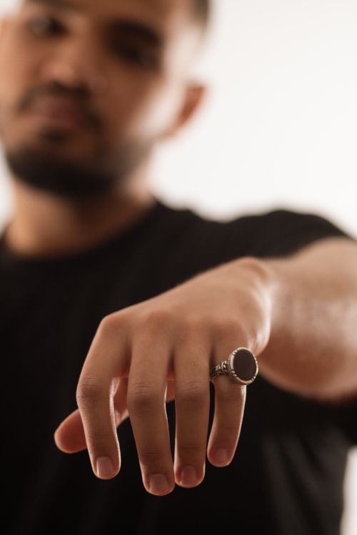 Free A close-up shot focusing on a man's ringed hand, showcasing jewelry with a blurred background. Stock Photo
