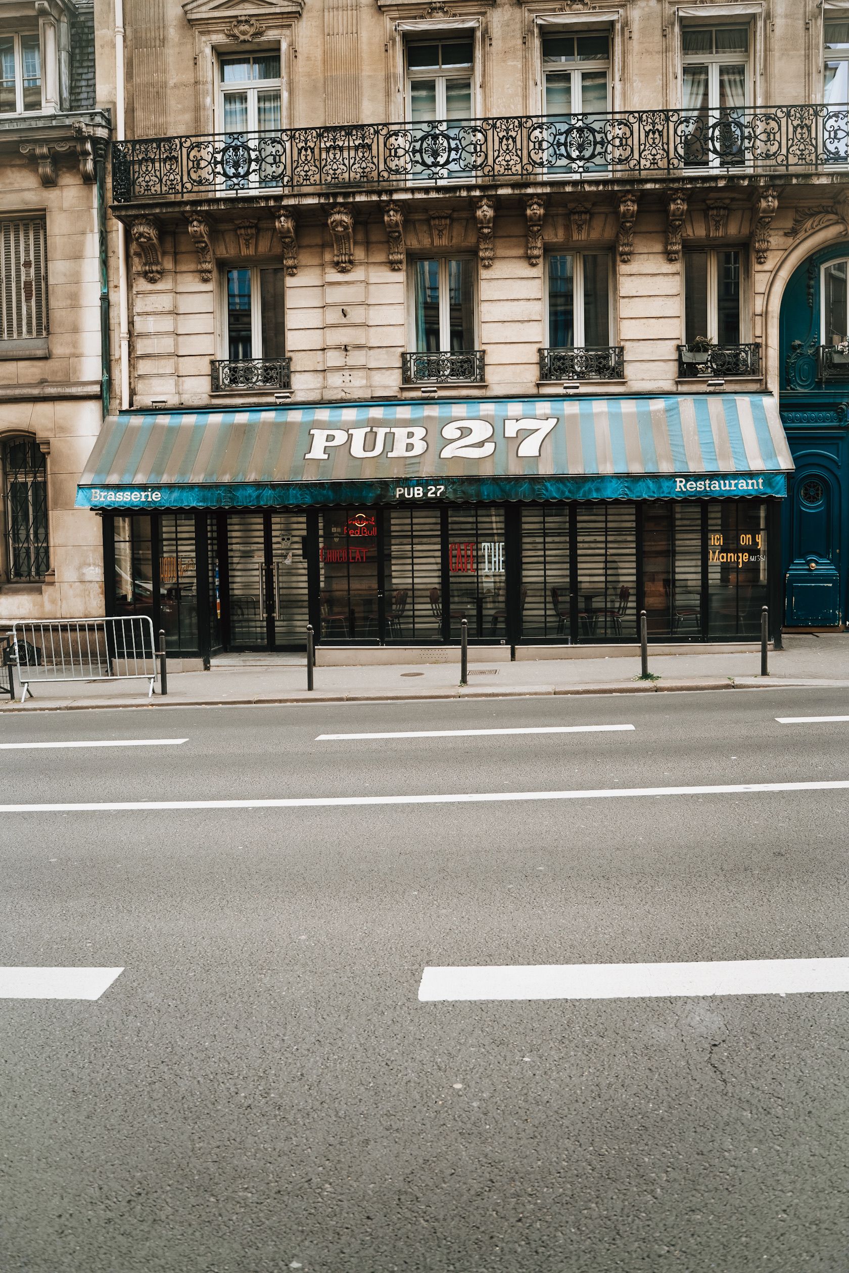 A classic city street scene featuring Pub 27's storefront with ornate balconies above.
