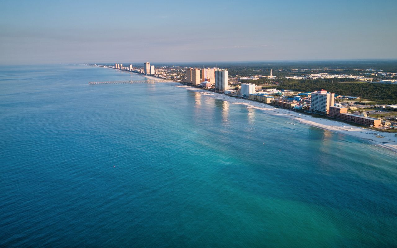 Stunning aerial view of Panama City Beach's coastline with clear blue waters and skyscrapers in view.