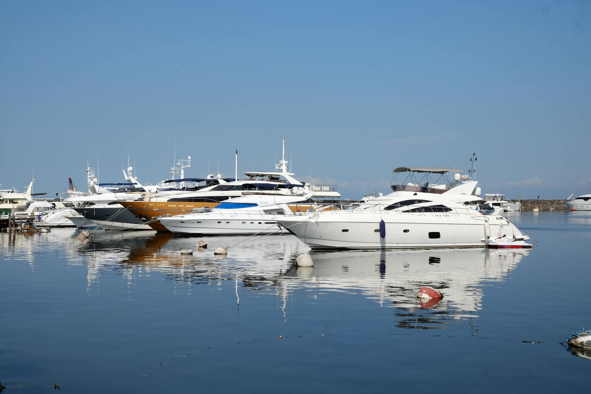 A serene view of luxury yachts moored at Pasay Marina, NCR, Philippines during a sunny day.