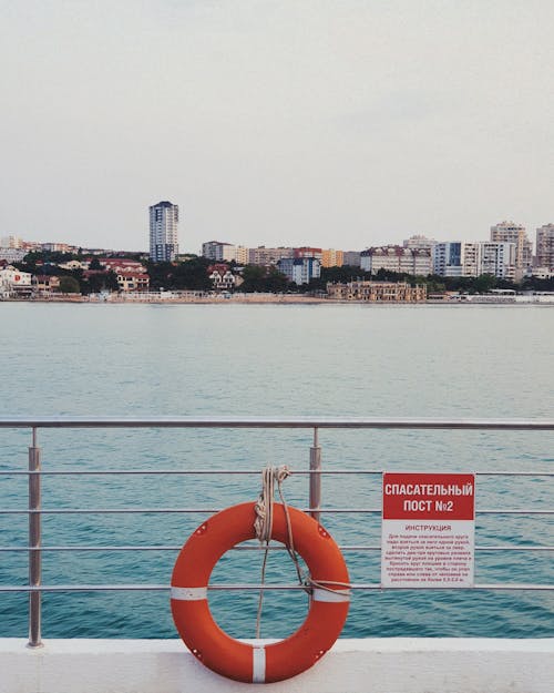 A life preserver on a pier with a city in the background