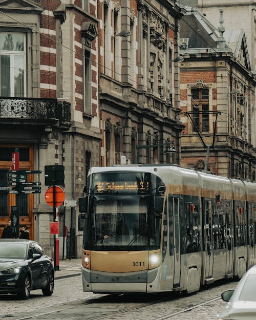 A city bus driving down a street with buildings in the background