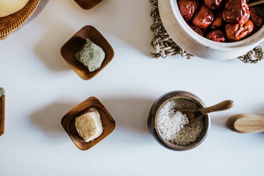 Top view of various dried ingredients and rice in wooden bowls on a white background.