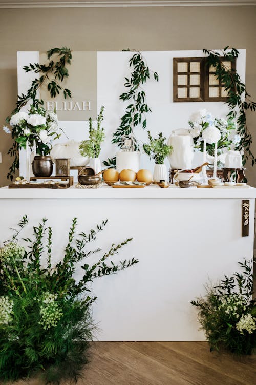 A white table with flowers and greenery