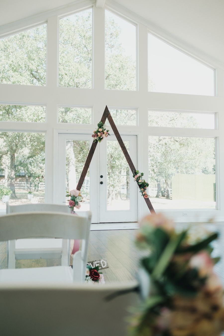Wooden bath tray with candles, flowers, and bath essentials over a bathtub