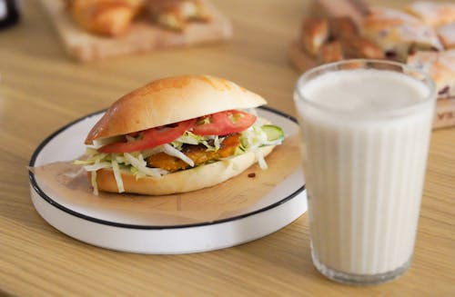Burger and Glass of Milk on Table