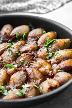 Close-up of flavorful fried shallots garnished with parsley in a frying pan. Perfect for food photography.