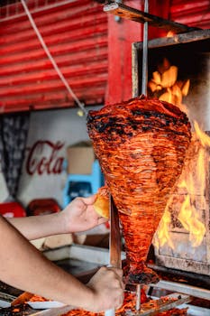 Hands carving al pastor in a traditional Mexican street setting, Oaxaca.