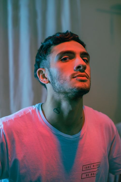 Free Stylish portrait of a young man with piercing under dramatic lighting. Stock Photo