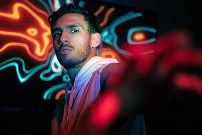 Portrait lit by coloured neon — photo by Sergio López on Pexels