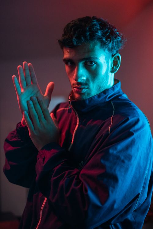 Free Moody portrait of a man in neon lighting with a stylish jacket. Stock Photo