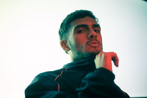 Free Stylish portrait of a young man in a tracksuit with dramatic lighting, exuding confidence. Stock Photo