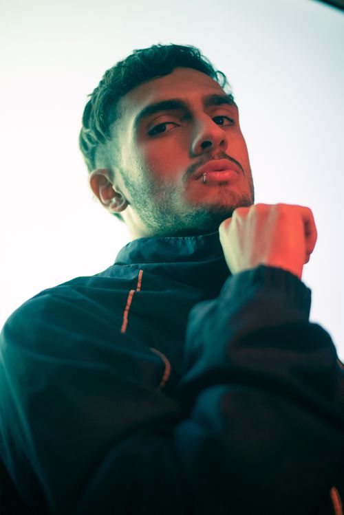 Free Artistic vertical portrait of a man in a tracksuit with dramatic lighting. Stock Photo