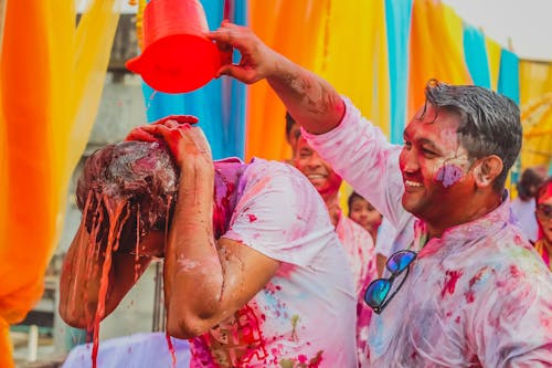 Man Pouring Colored Liquid to Another Man