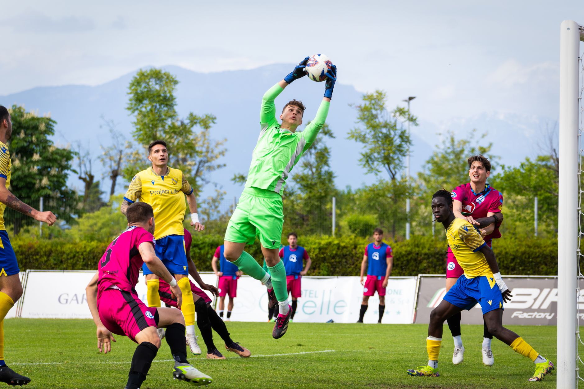 Goalkeeper in action during an intense soccer match with diverse players.