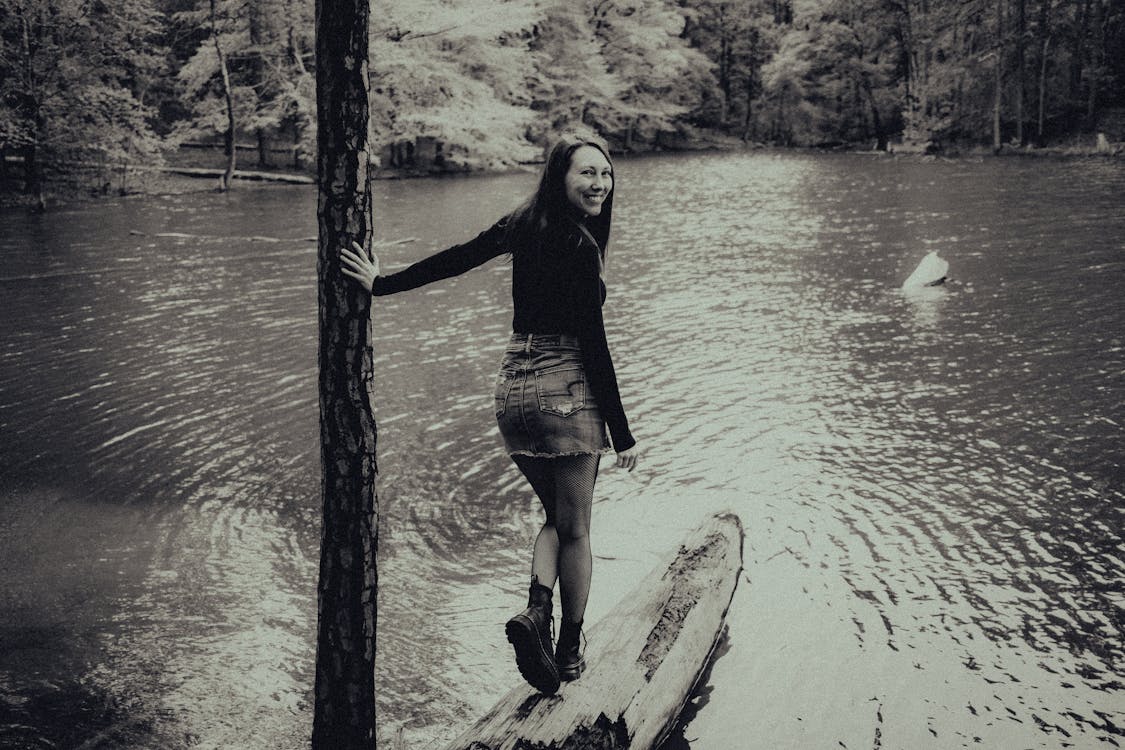 A woman standing on a log in the water