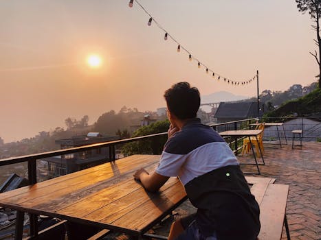 一名男子在露台上俯瞰风景，欣赏宁静的日落