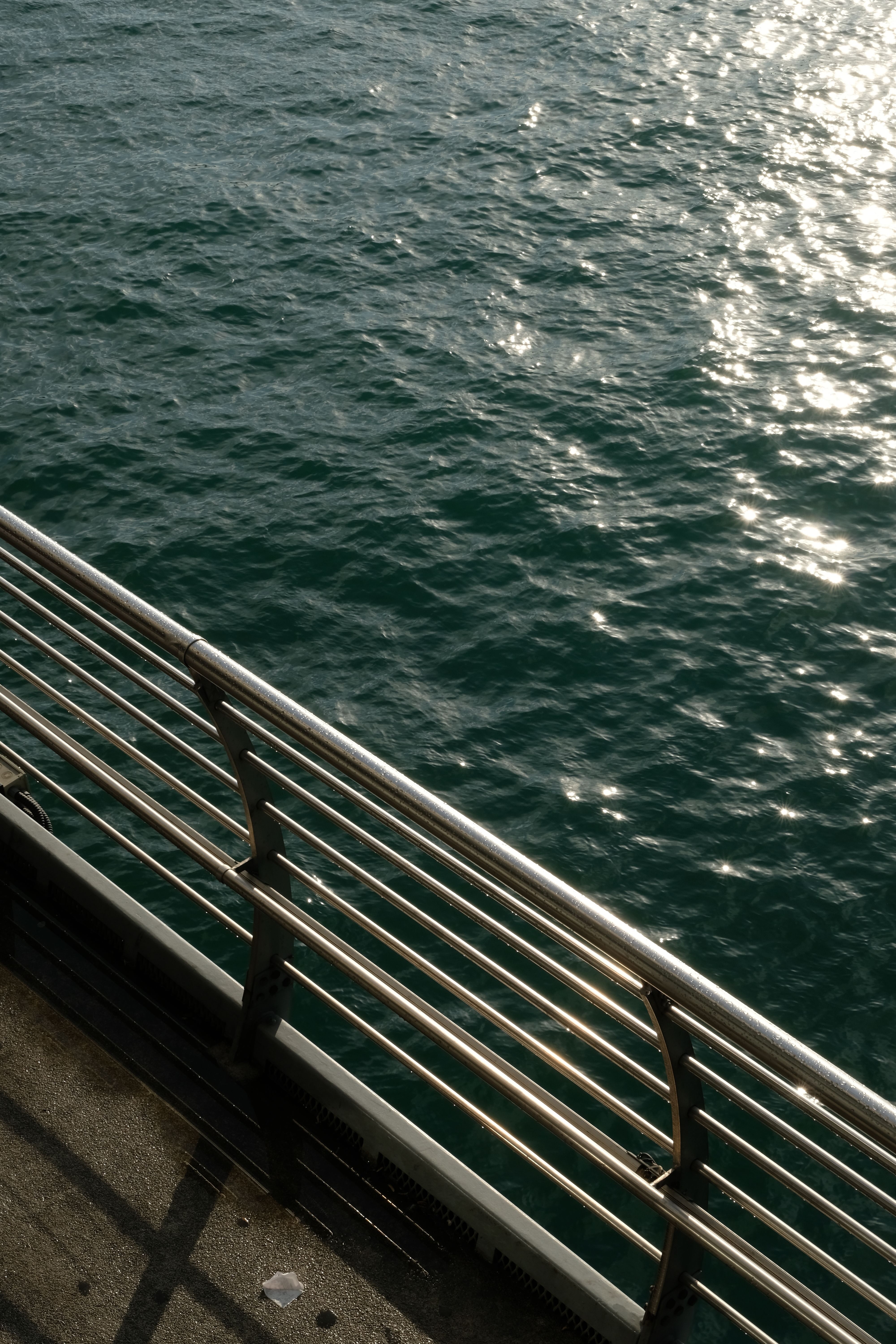 Water Reflecting Sunlight And a Ship Railings · Free Stock Photo