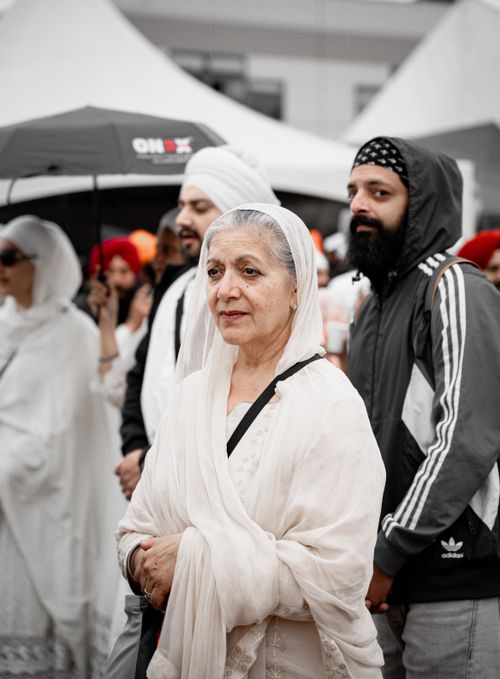Free A multicultural crowd dressed in traditional attire stands together at an outdoor event. Stock Photo