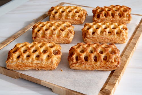 A tray of six mini pies on a wooden board