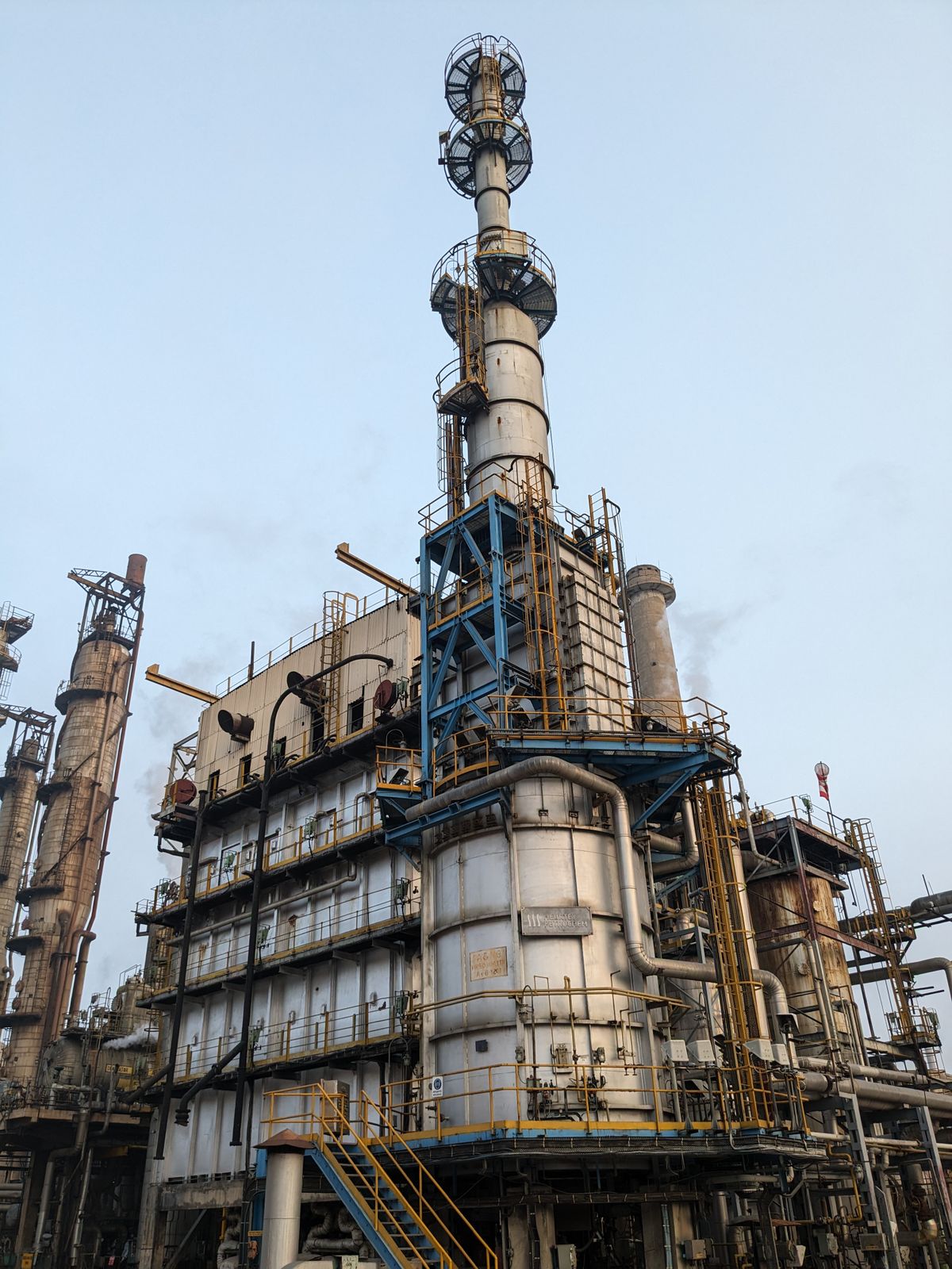Low-angle view of a gas and petrochemical refinery undergoing shutdown and turnaround crane inspection in Australia