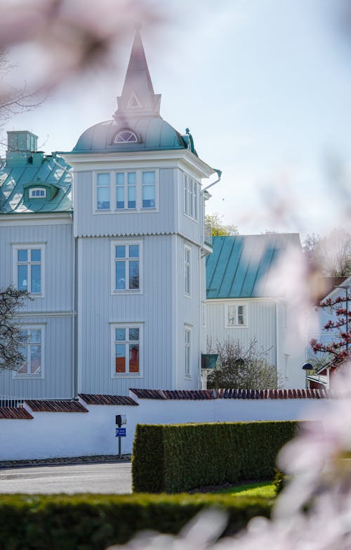 A white house with a pink flower in front